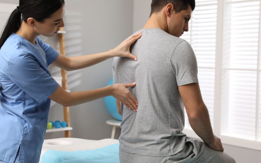 Orthopedist examining man's back -Post-surgical Spine Rehabilitation Texas
